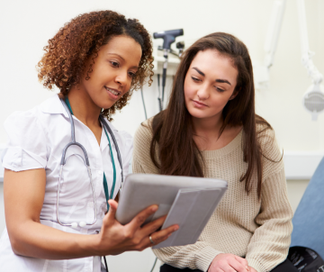 a nurse and a patient looking at a tablet